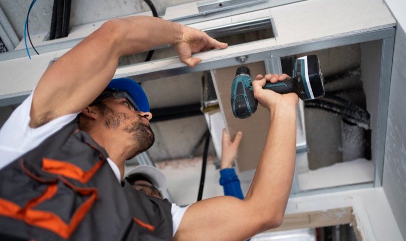T&eacute;cnicos instalando dutos de climatiza&ccedil;&atilde;o no teto